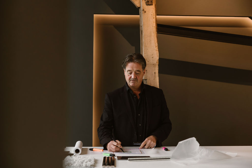 Interieurarchitect werkt aan plattegrond en materiaalstalen op werktafel
